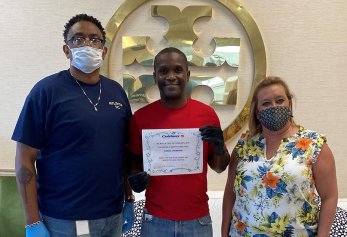 CoWorx employee holding up certificate with colleagues standing by