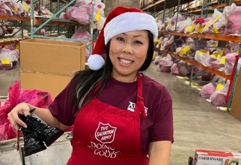 CoWorx worker in The Salvation Army apron and Santa hat